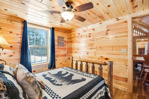 a log cabin bedroom with a bed and a ceiling fan at Meandering Moose Cabin in Florissant