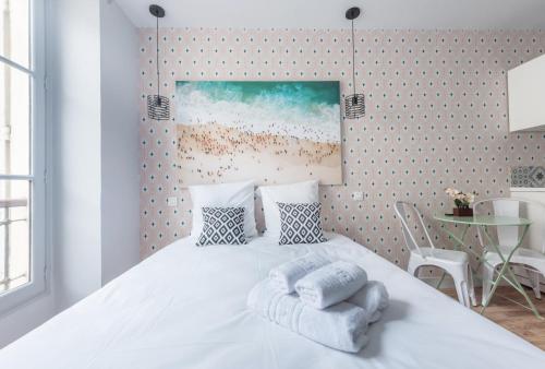 une chambre avec un lit blanc avec des serviettes dessus dans l'établissement WS Opéra - Galeries Lafayette, à Paris