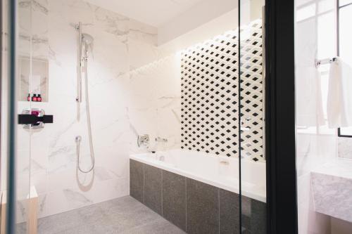 a bathroom with a shower and a bath tub at Fauchon Hotel Kyoto in Kyoto