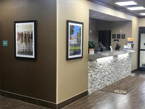 a lobby with a counter and two pictures on the wall at Comfort Inn Pinehurst - Southern Pines in Pinehurst