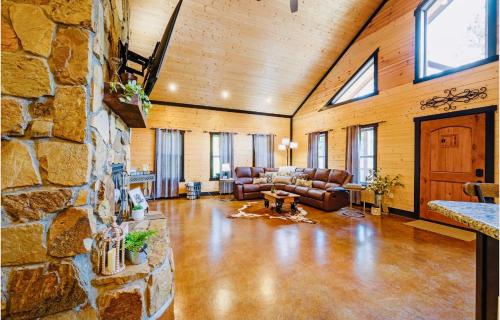 a large living room with a stone wall at Knotty and Nice Luxury Cabin in Broken Bow
