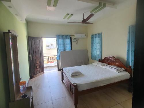 ein Schlafzimmer mit einem Bett in einem Zimmer mit einem Fenster in der Unterkunft Hallima Home Stay Purpose Guest Bungalow House 1 in Pudukkottai