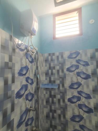ein Bad mit einer Dusche mit an der Wand gemalten Fischen in der Unterkunft Hallima Home Stay Purpose Guest Bungalow House 1 in Pudukkottai
