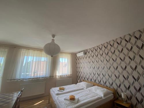 1 dormitorio con cama y pared en Barki Apartman, en Bük
