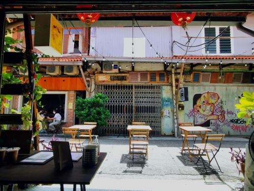 a group of tables and chairs in front of a building at LEJU 8 樂居 Loft living with open air bathroom in Melaka