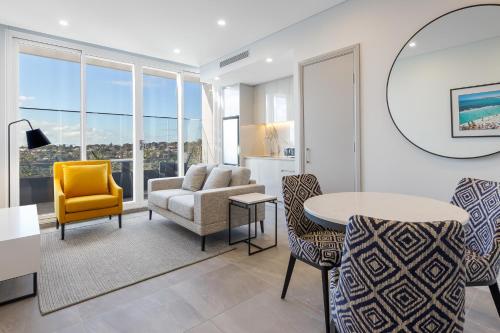 雪梨的住宿－邦迪交界處美利通公寓式酒店，客厅配有沙发和桌椅