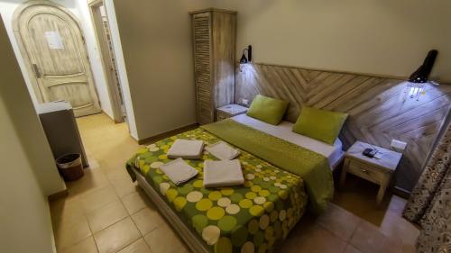 a bedroom with a large bed with green and yellow sheets at Shams Hotel & Dive Centre in Dahab