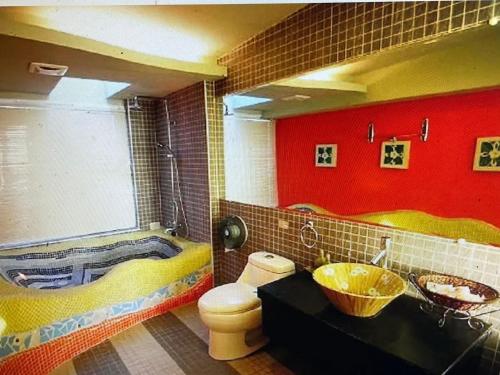 Fei Li Jin Hotel في كنتيج: حمام مع حوض ومرحاض وحوض استحمام