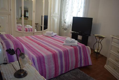 a bedroom with a bed with a pink and white blanket at Al Borghetto in Montegrino Valtravaglia