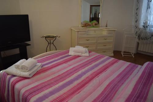 a bedroom with a bed with two towels on it at Al Borghetto in Montegrino Valtravaglia