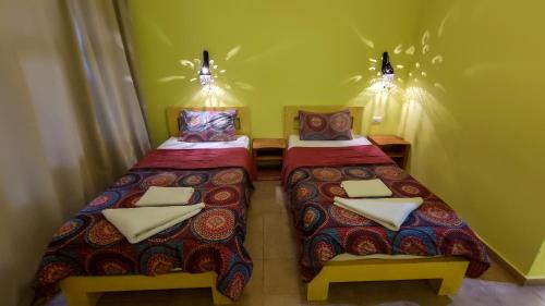two beds in a small room with lights on at Shams Hotel & Dive Centre in Dahab