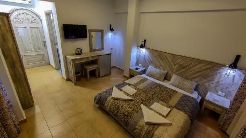 a bedroom with a bed and a desk and a television at Shams Hotel & Dive Centre in Dahab