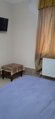 a bed and a table in a room at шорена in Batumi