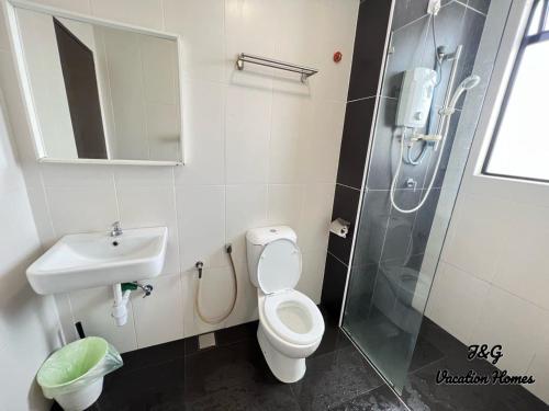 a bathroom with a toilet and a sink and a shower at The Garden By J&G Vacation Homes in Skudai
