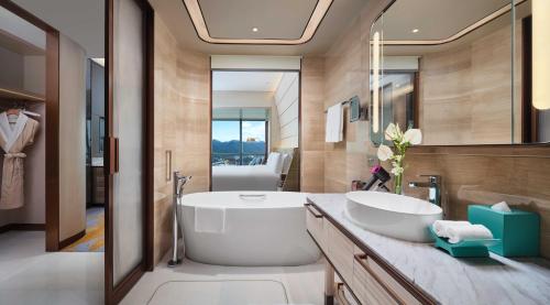 a bathroom with a large white tub and a sink at InterContinental Chongqing Raffles City by IHG in Chongqing