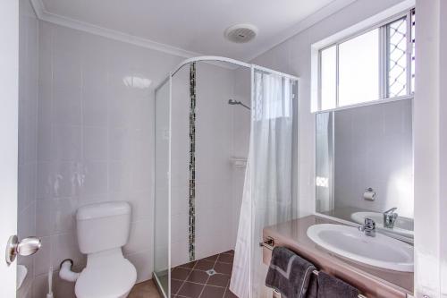 La salle de bains est pourvue de toilettes, d'un lavabo et d'une douche. dans l'établissement Galaxy Mackay Motor Inn, à Mackay