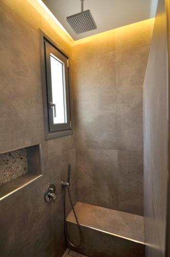 a bathroom with a shower with a sink and a window at Kyanis Villa , Karpathos Afiartis in Afiartis