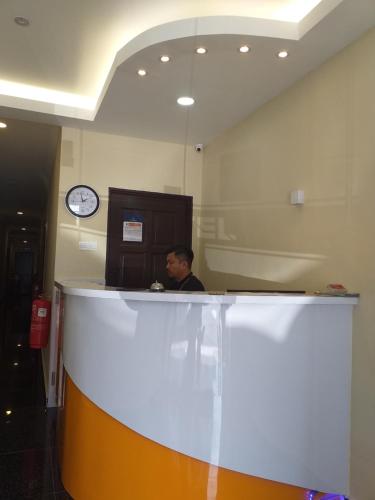a man sitting at a counter in an office at Hentian Hotel Kajang in Kajang