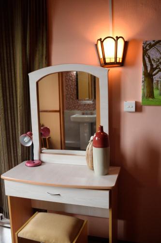 a bathroom with a vanity with a mirror and a lamp at Villa La Romance Kreol in Rodrigues Island