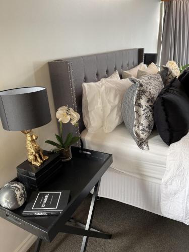 a bed with pillows and a table with a lamp at Araluen Boutique Accommodation in Yarra Glen