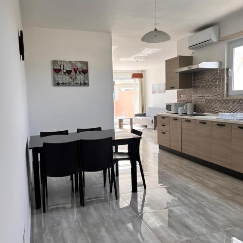 a kitchen with a black table and chairs in it at F6 Room 2, Private Room two single beds shared bathroom in shared Flat in Msida