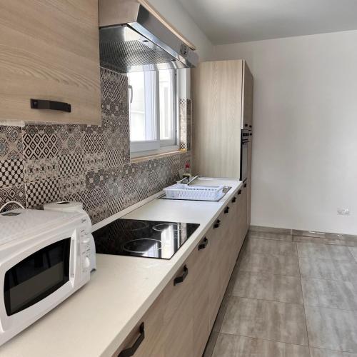 a kitchen with a white microwave and a sink at F6 Room 2, Private Room two single beds shared bathroom in shared Flat in Msida