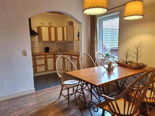 eine Küche und ein Esszimmer mit einem Holztisch und Stühlen in der Unterkunft Beautiful apartment in a former coach house in the Harz in Elbingerode