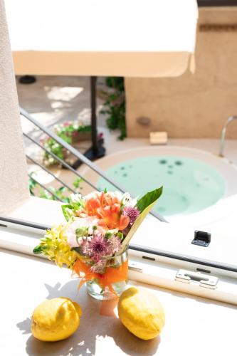 a vase of flowers on a table in front of a bath tub at Corte Alma Spa and Luxury Home in Gargnano
