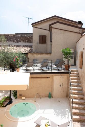 a patio with chairs and a hot tub on a building at Corte Alma Spa and Luxury Home in Gargnano