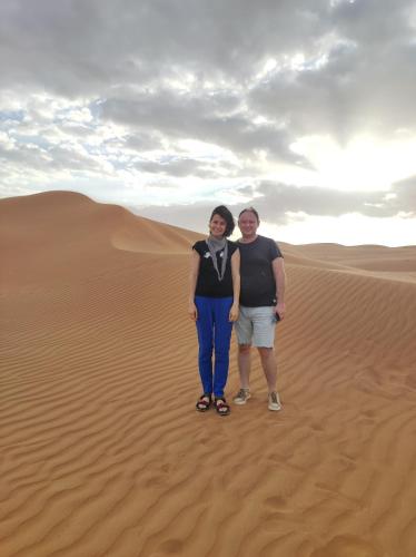 two people standing in the sand in the desert at SandGlass Camp in Bidiyah