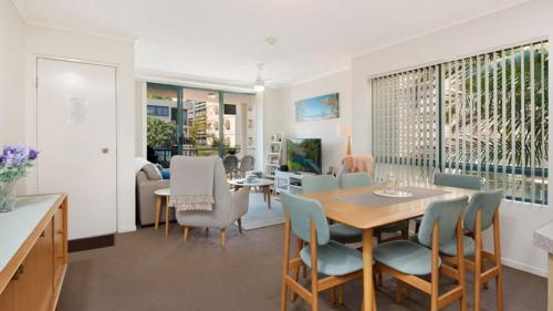a dining room and living room with a table and chairs at Unit 2 'fair Haven' Kings Beach in Caloundra