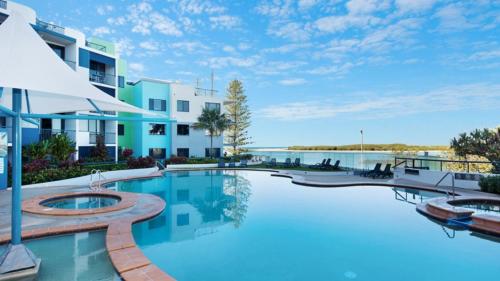 a swimming pool in front of a building at #55 Grand Pacific Resort, Outdoor Spa With A View! in Caloundra