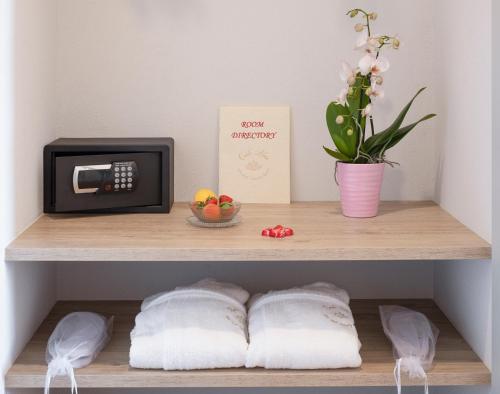 a shelf with a microwave and a plant and towels at Corte Alma Spa and Luxury Home in Gargnano