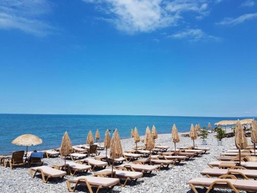 a beach with chairs and umbrellas and the ocean at Dreamland deluxe apartment in Chakvi