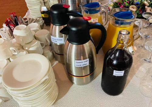a table topped with plates and coffee pots and pans at Hotel Shumon in Dushanbe