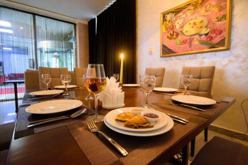 a wooden table with a plate of food and wine glasses at Hotel Shumon in Dushanbe