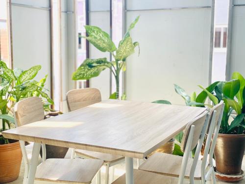 a wooden table and chairs in a room with plants at BE Rendez Vous Hotel in Patong Beach