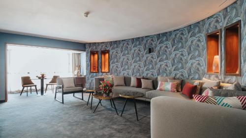 a living room with a couch and some chairs at Idou Anfa Hôtel & Spa in Casablanca