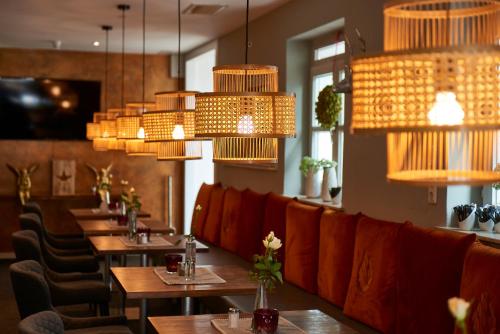 a restaurant with tables and chairs and chandeliers at Hotel Domizil in Ingolstadt