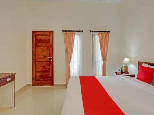 a bedroom with a bed and a wooden door at The Bingin Sari Jimbaran in Jimbaran
