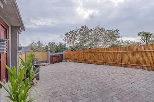 a patio with a wooden fence next to a house at The Bingin Sari Jimbaran in Jimbaran