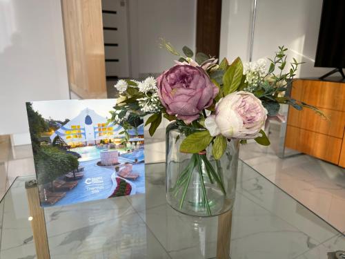 a vase filled with flowers sitting on a table at Spa Residence Carbona Royal Suites 1.11 in Hévíz