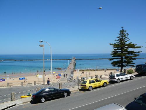 a street with cars parked next to a beach at McCloud House in Port Noarlunga