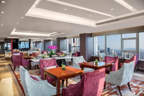 a restaurant with tables and chairs and windows at Crowne Plaza Shenzhen Futian, Near to Shenzhen Convention&Exhibition Centre, Shenzhen Stock Exchange and Shenzhen Civic Center, Outdoor Heated Pool in Shenzhen
