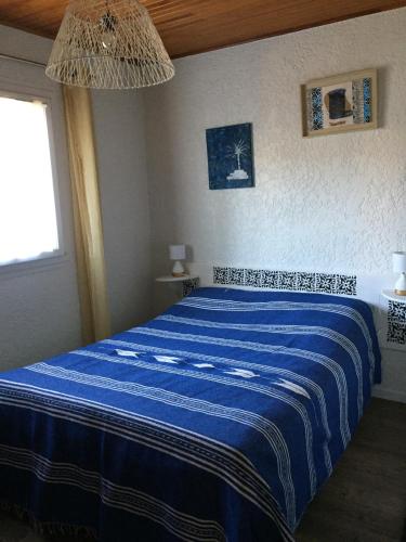 - une chambre avec un lit bleu et une couverture bleue dans l'établissement Maison chaleureuse climatisée à Maubuisson, proche lac, à Carcans
