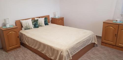 a bedroom with a large bed with two night stands at Rózsa apartman in Odorheiu Secuiesc