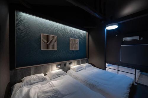 a bedroom with two beds and a wall with two posters at trive ozone バンテリンドーム ナゴヤ近く 都心部好アクセス 大曽根駅 徒歩3分 in Nagoya