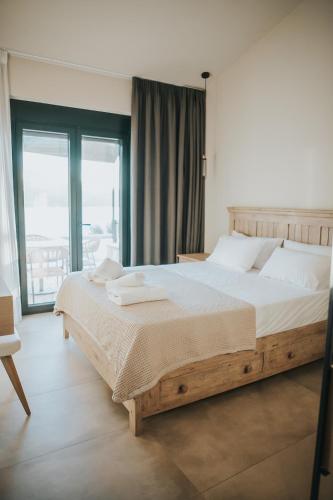a bedroom with a large bed and a large window at Elia Luxury Suites in Plataria