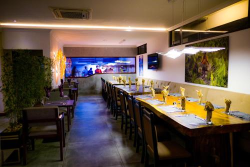 uma sala de jantar com uma mesa longa e cadeiras em MERCURE HOTEL em Antananarivo