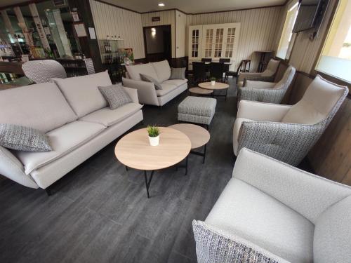 a living room with couches and tables and chairs at Hotel Querol in Valderrobres